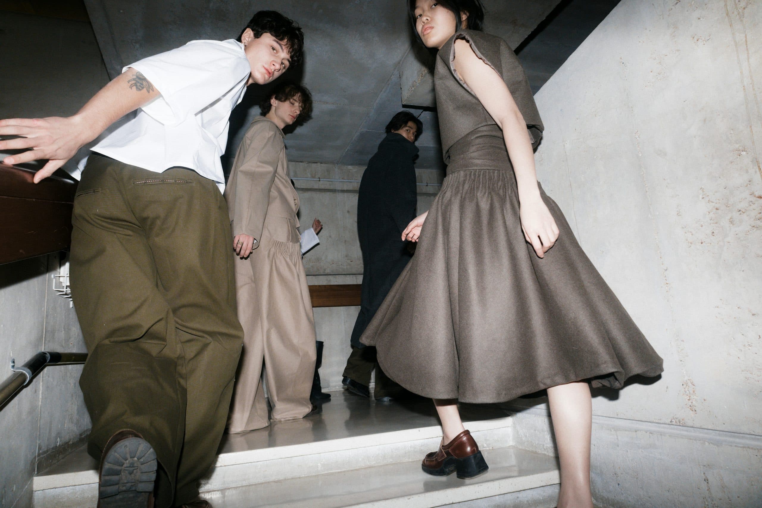 Modelos bajando una escalera de hormigón durante Fashion Week